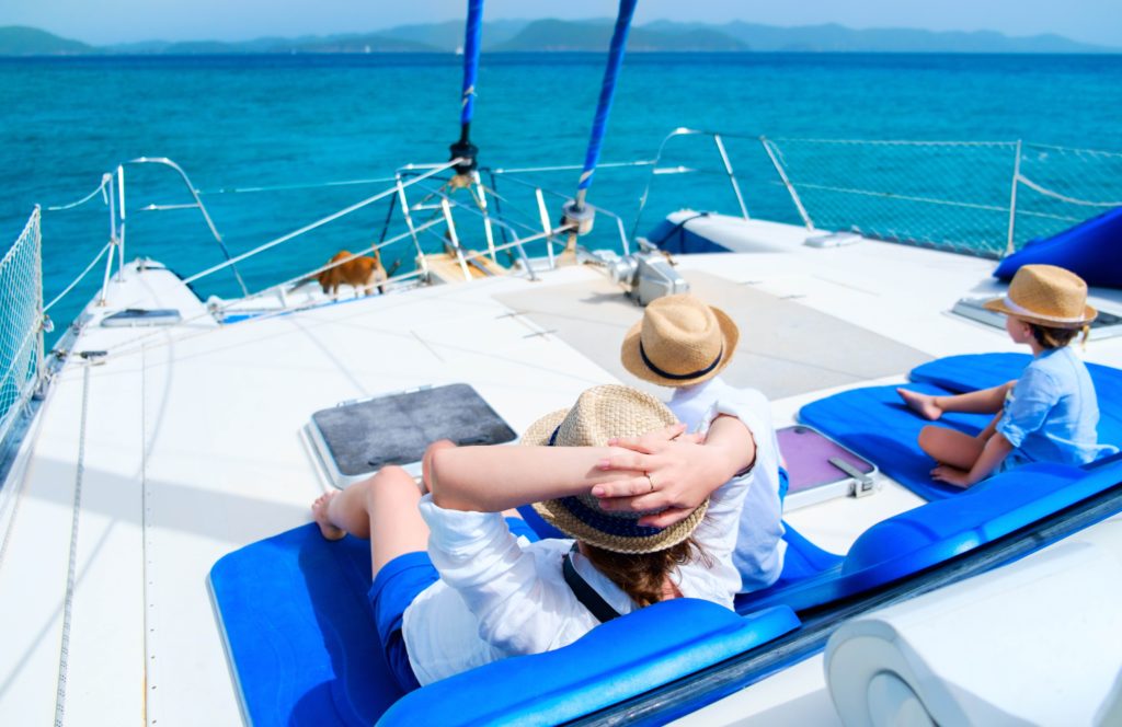View of a family of three on the deck of the catamaran watching the sea