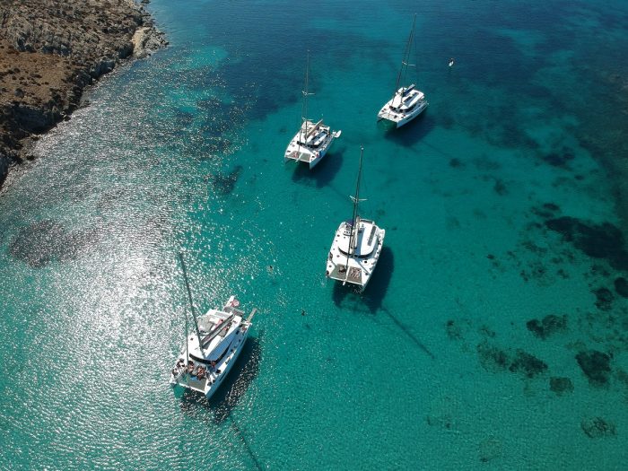 Aerial view of 4 catamarans on the clear blue water