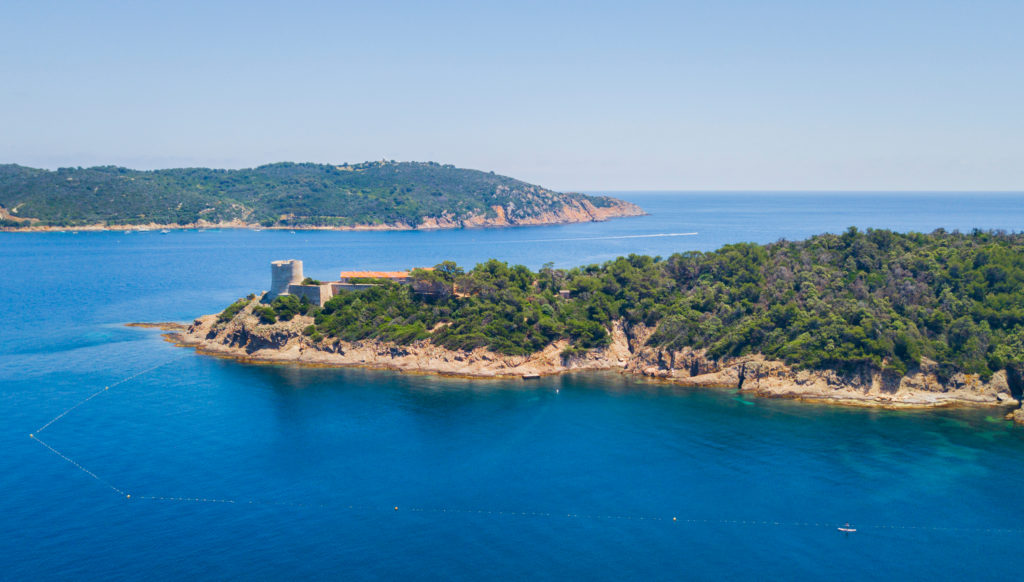Aerial view of the Port Cros island showing the clear blue sea and the forest