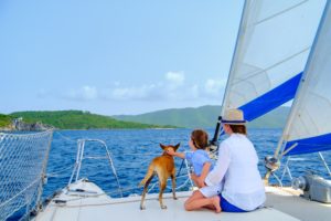 Mother and daughter on a sailboat with their dog on board