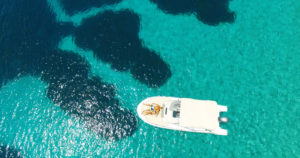 Aerial view of a couple on a yact in the middle of the sea