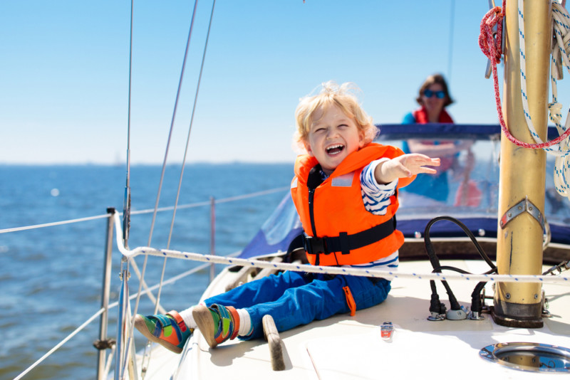 kid sailing with life jacken on