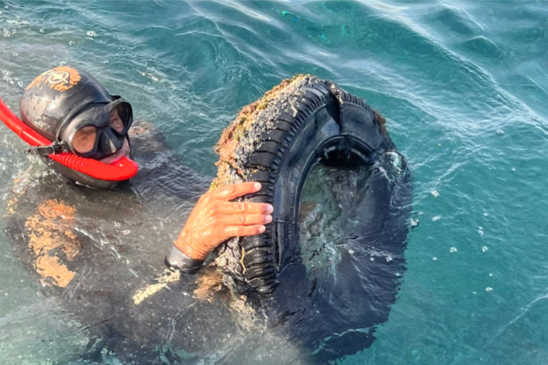 Diver removing a tyre from the sea