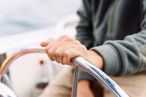 Person steering a boat while enjoying a day at sea