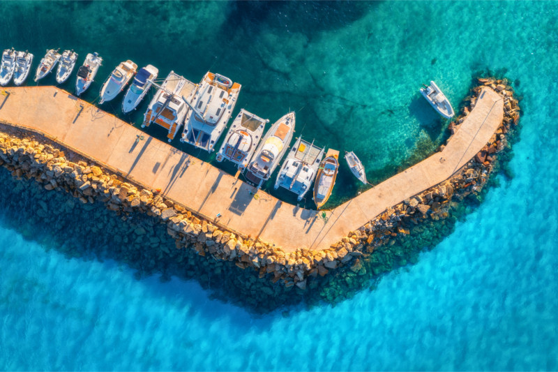 Aerial view of motorboats and catamarans moored in a marina with turquoise waters
