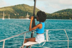 Person observing the coastline from a sailboat